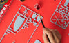 A half assembled Airfix kit being painted by an Adult or Child on a red background.