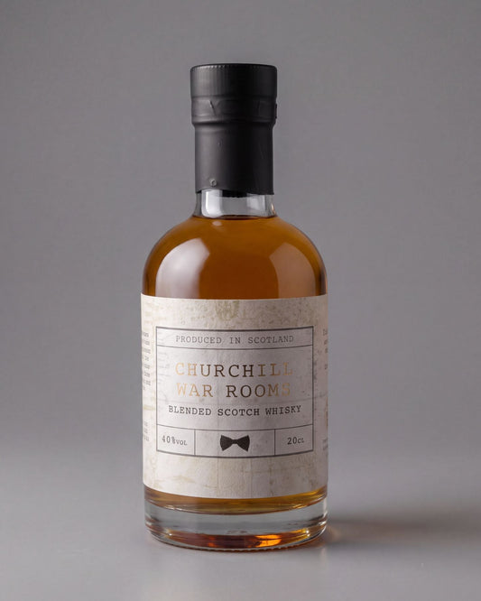 A bottle of Churchill War Room Blended Scotch Whisky on a neutral gray background. The bottle is made of clear glass showing the amber liquid inside, topped with a black cap and featuring a cream-colored label with black text and a small bowtie graphic.