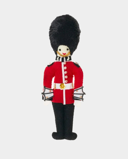Handmade felt decoration resembling a member of the Queen's Guard, with a red uniform and black plume.