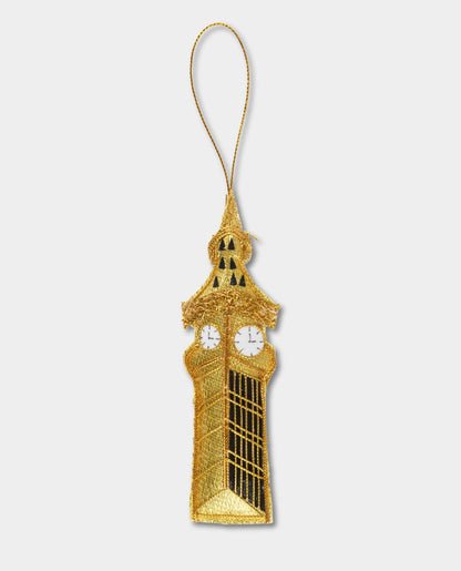 A golden felt decoration resembling the Big Ben clock tower with a string attached for hanging.