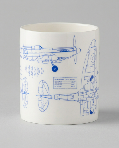 White mug with blue airplane blueprint design on a gray background