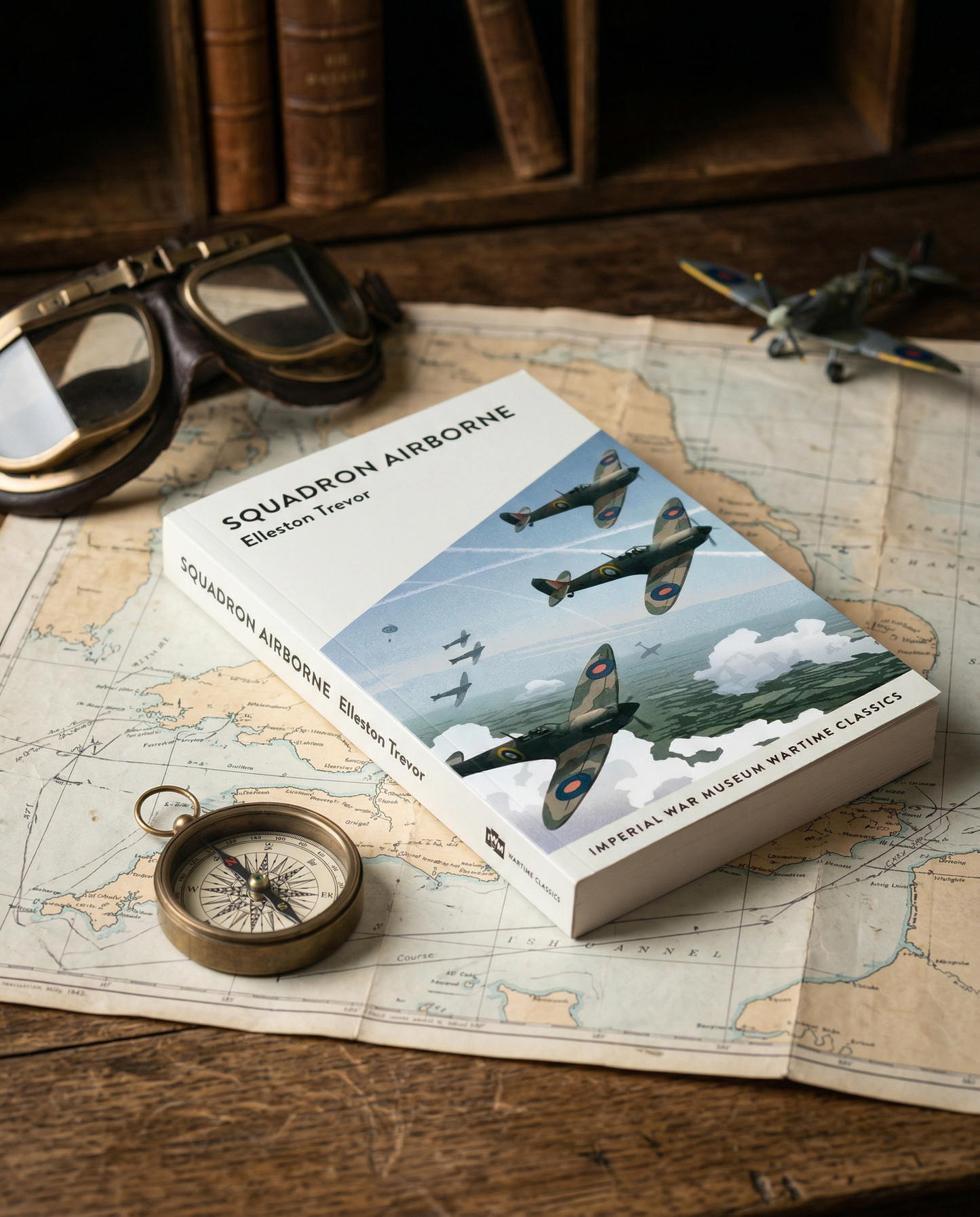 Book titled 'Squadron Airborne' on a map with goggles and compass