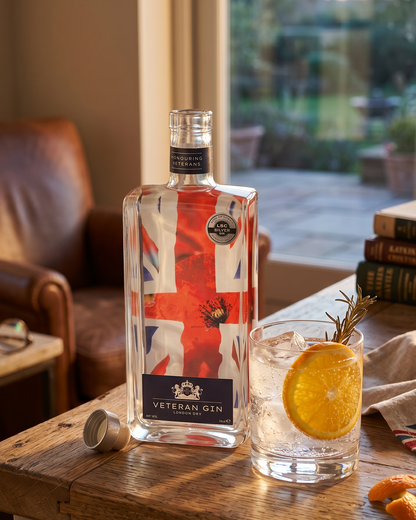 Bottle of Veteran gin with a Union Jack design on a wooden table, accompanied by a glass of gin and tonic.