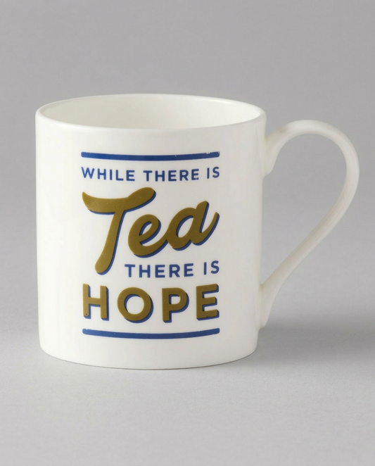 White mug with 'While there is tea, there is hope' text on a gray background